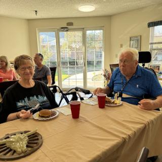Seniors enjoying a meal together in a communal dining area.