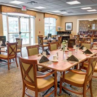 A well-lit dining area with neatly arranged tables and chairs, featuring elegant interior decor.