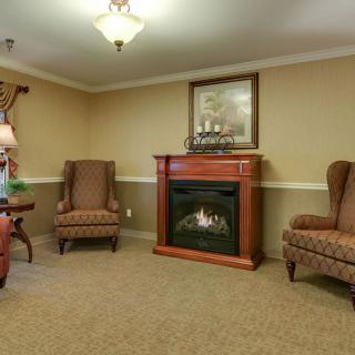A cozy living room with a fireplace and armchairs.