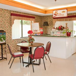 A cozy cafe setting featuring a small table and chairs with floral decor.
