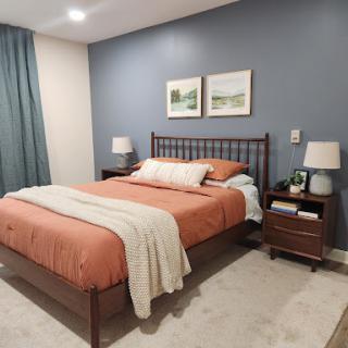 A modern and cozy bedroom featuring a comfortable bed, stylish nightstands, and tasteful artwork on the walls.