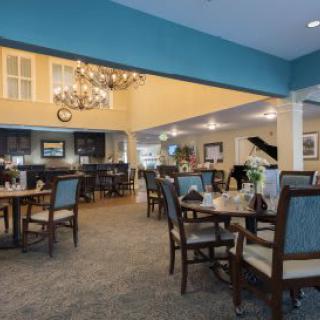 Elegant dining area with a chandelier and piano.
