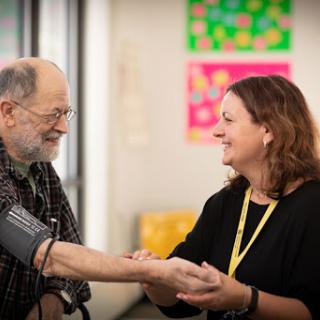 A joyful interaction between a healthcare professional and an elderly patient during a routine check-up.