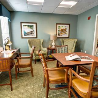 A cozy office space with desks, chairs, and a reading area.
