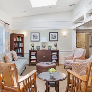 A cozy living room with comfortable seating, a bookshelf, and natural lighting.