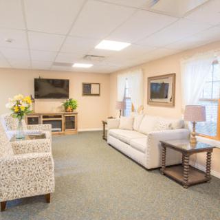 A cozy and modern living room space featuring a comfortable white sofa, stylish armchairs, and a television.