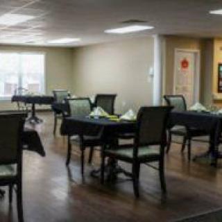 An empty dining room with tables and chairs arranged neatly.