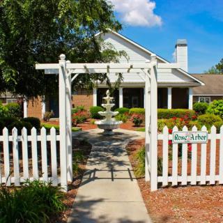 A charming house with a white picket fence and a garden fountain.