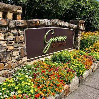 A beautifully landscaped entrance sign adorned with colorful flowers.