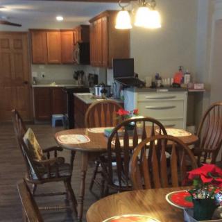 A cozy kitchen and dining area with wooden furniture and decorative flowers.