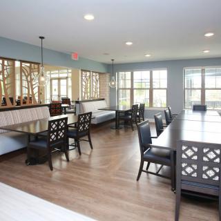 A spacious dining room with elegant furniture and large windows.