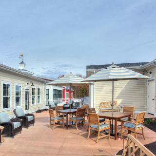 An inviting outdoor patio area featuring tables, chairs, and umbrellas for relaxation.