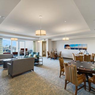 A spacious and modern living room with a dining area, featuring comfortable seating and elegant lighting.