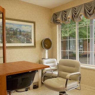 A cozy office space with a desk, chair, and large window.