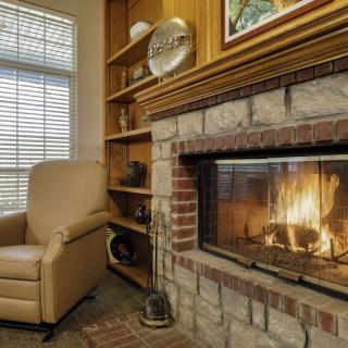 A cozy living room with a warm fireplace and a comfortable chair.