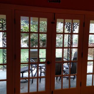 View of a patio with outdoor furniture through French doors.