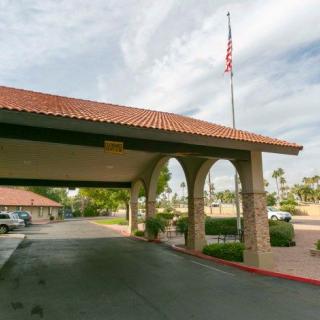 Entrance to a building with arches and an American flag on a flagpole.