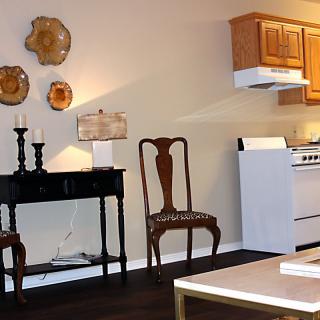 A cozy kitchen with elegant wooden furniture and decorative wall accents.
