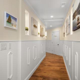 A beautifully designed hallway featuring artistic wall decor and warm wooden flooring.