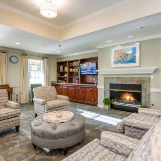 A cozy living room with a fireplace, comfortable seating, and elegant decor.