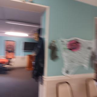 A glimpse into an office space decorated with spooky elements, featuring blue walls and chairs.