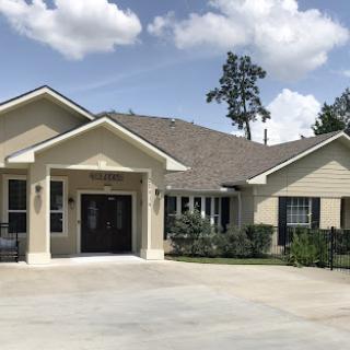 A charming single-story house with a welcoming entrance and well-maintained landscaping.