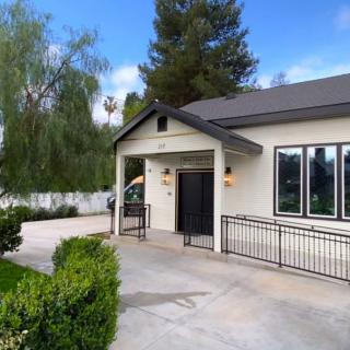 A modern single-story house with a manicured landscape and driveway.