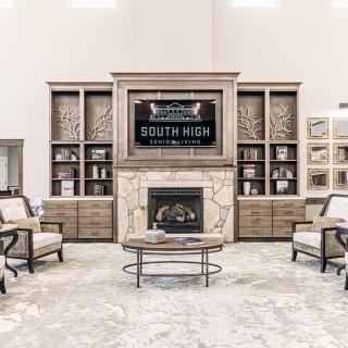 A well-designed living room featuring a central fireplace, surrounded by built-in bookshelves and comfortable seating.
