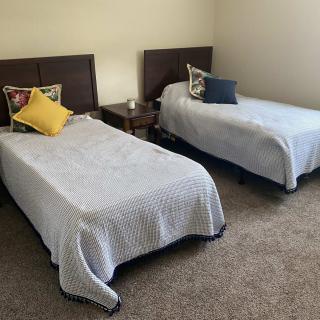 A cozy bedroom with two twin beds adorned with pillows.