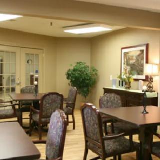 A cozy dining area with tables, chairs, and warm lighting.
