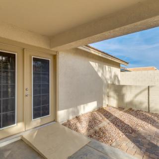 Sunny patio with French doors leading to a small backyard area.