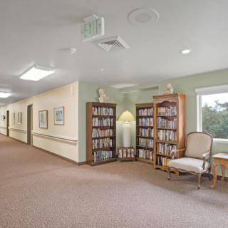 A quiet hallway with bookshelves and a seating area.