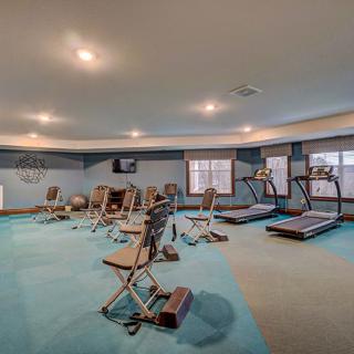A spacious gym with various exercise equipment including treadmills and strength machines.