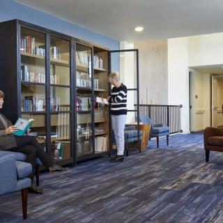 People reading and browsing books in a cozy library setting.