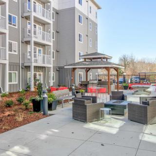 Modern apartment complex with a furnished outdoor patio and gazebo.