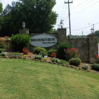 Entrance sign to a neighborhood with well-maintained landscaping and flowers.