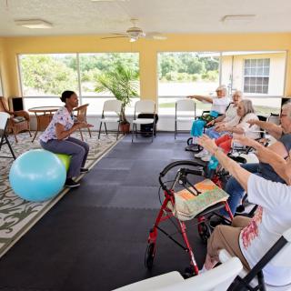 A group of seniors participating in an exercise class led by an instructor.