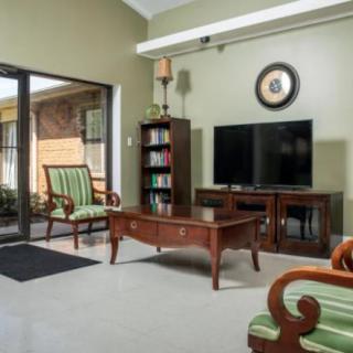 A cozy living room with classic wooden furniture and a television set.