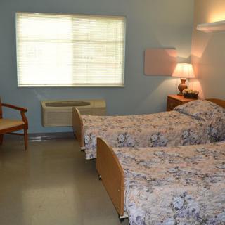 A cozy bedroom with twin beds and soft lighting.
