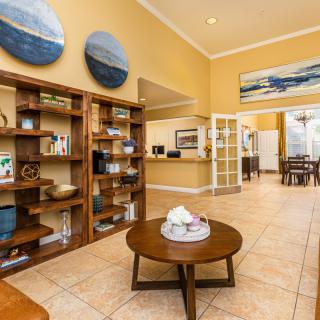 A modern lobby area featuring wooden bookshelves, contemporary artwork, and a reception desk.