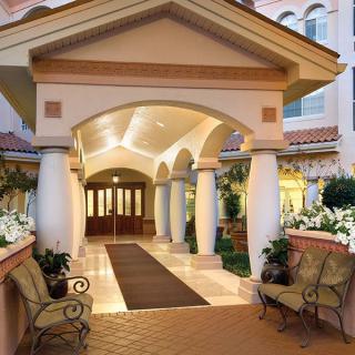 Elegant hotel entrance with columns and seating area.