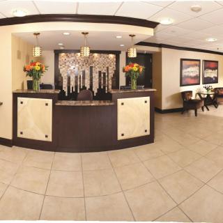 A modern hotel lobby with a reception desk and elegant decor.