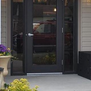 A welcoming front entrance with a glass-paneled door and potted plants.