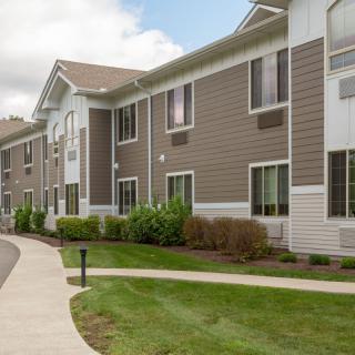 A modern building with well-maintained landscaping and a concrete pathway.