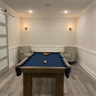 A modern game room featuring a blue billiard table and cozy seating.