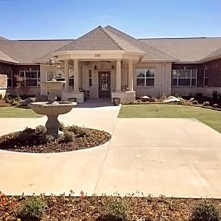 A single-story house with a neatly landscaped garden and driveway.