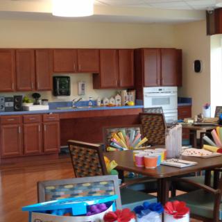 A cozy kitchen and dining area with wooden cabinets, tables, and chairs.