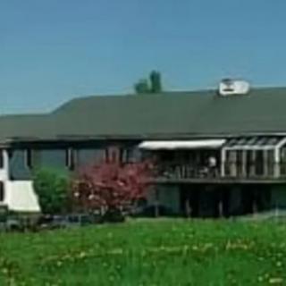 A picturesque house surrounded by a lush green landscape.