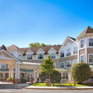 A sunny day view of a residential building with a well-maintained facade and landscaping.