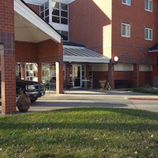 A view of a commercial building's entrance with a parking area in front.